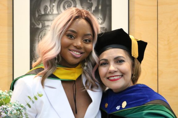 Two women smiling, graduation day
